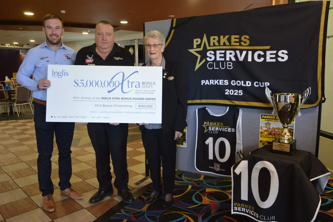 Parkes Jockey Club president Alex Prout with the $100,000 cheque for the Inglis Xtra Bonus Maiden Series, and 10-year Parkes Gold Cup major sponsor from the Parkes Services Club general manager Mike Phillips and president Dorothy Charlton. PHOTO: Christine Little