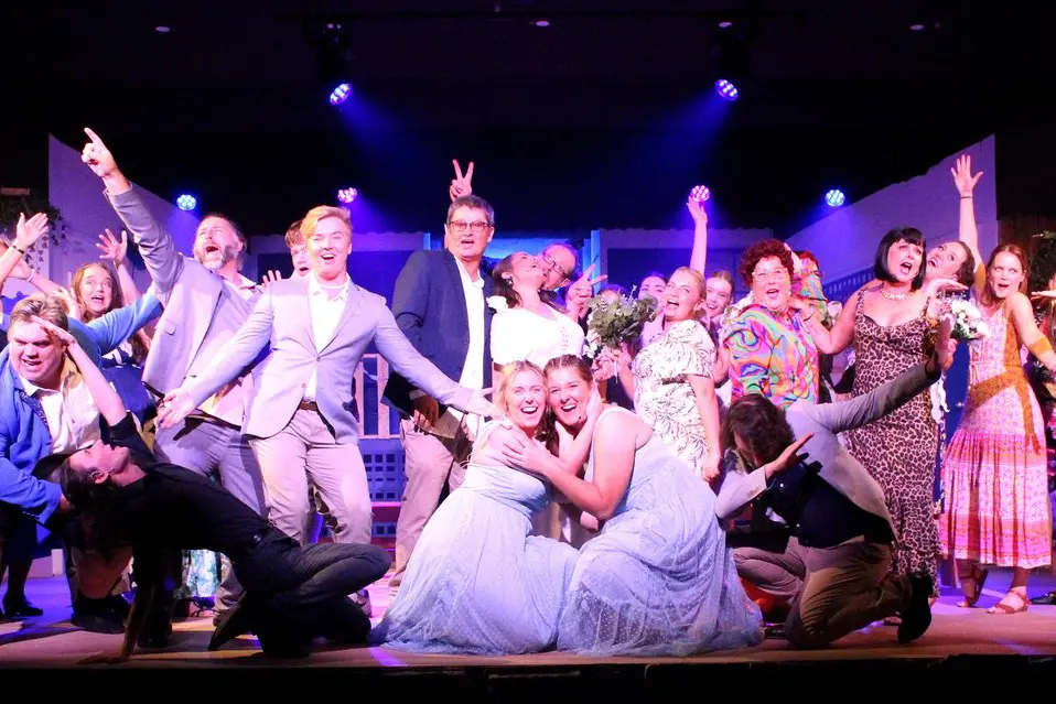 The cast having a ball in the wedding scene of Mamma Mia, which opens this Saturday night, 3 May. PHOTO: Supplied