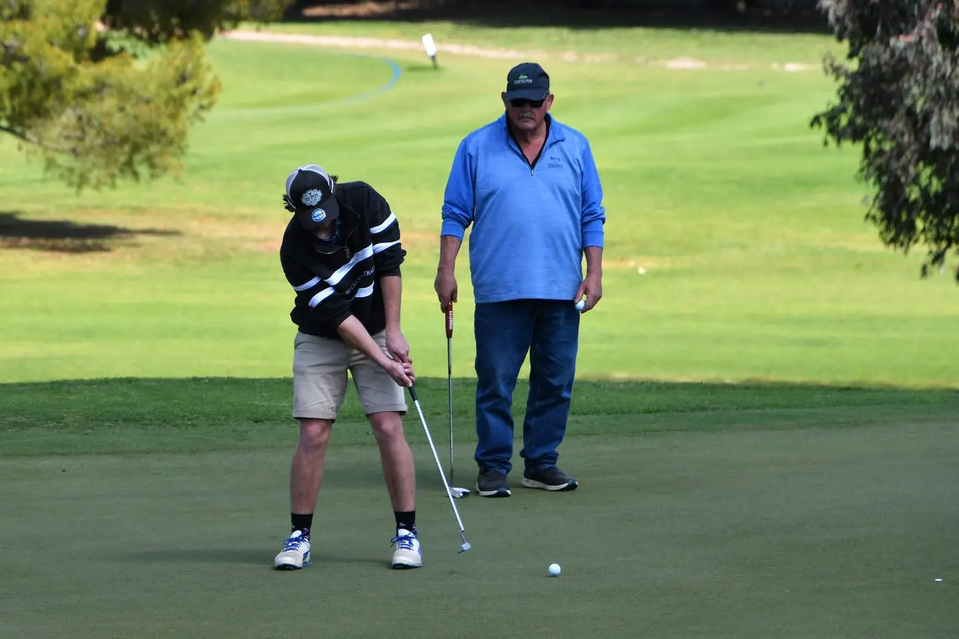 Jimmy Kuntze of Parkes putts, watched by Michael Hanlon from Condobolin. PHOTO: Jenny Kingham