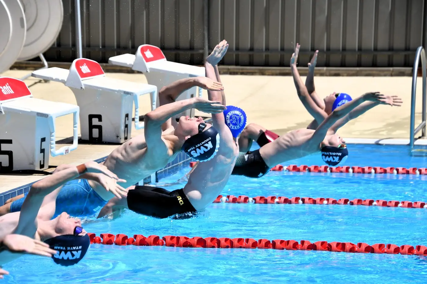 Boys backstroke launching from the blocks at the Parkes Swimming Pool.