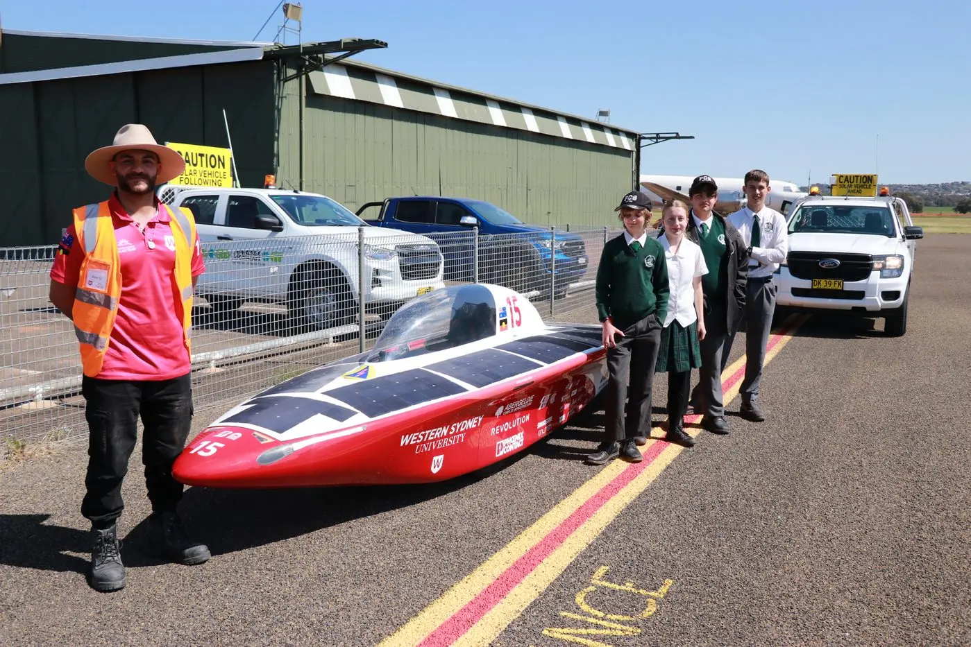 Solar car driver Alex Grima  with PCS students Liam Denmead, Rosie Parkin, Joshua Lynn and Angus Border. 