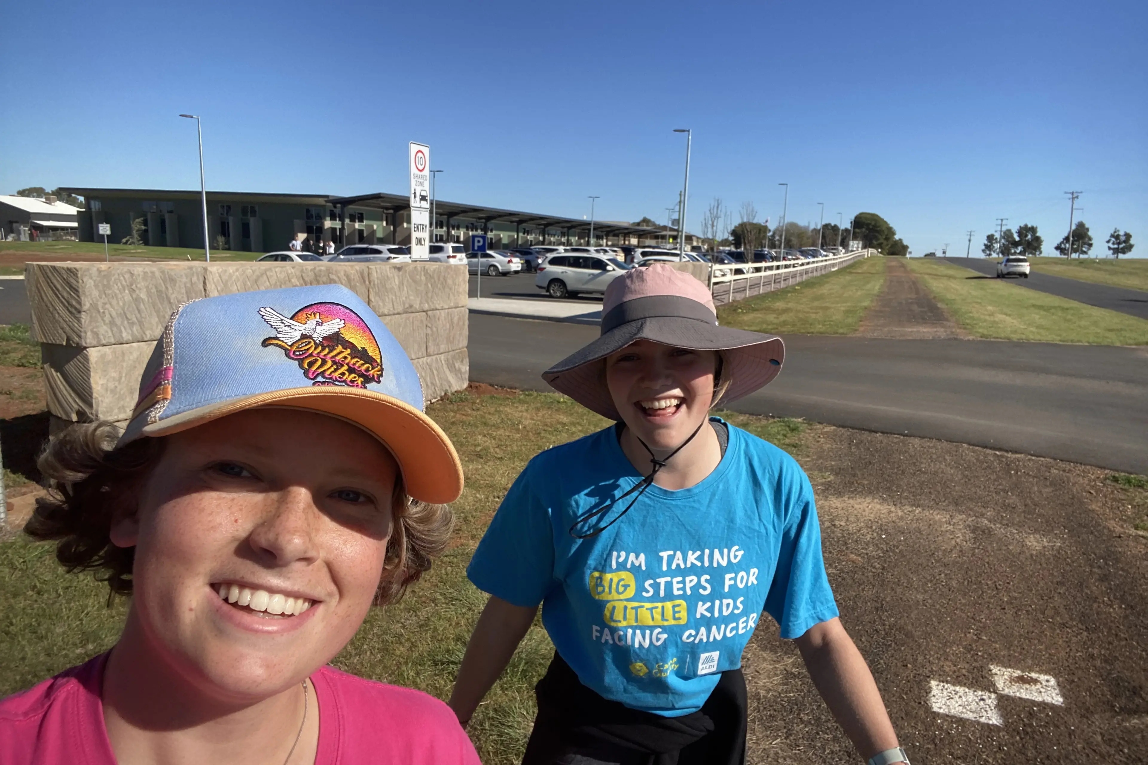 <p>Chloe and Clare Amery at the front of their school (Parkes Christian School) after walking 65km from their house starting the day before. </p>\\n