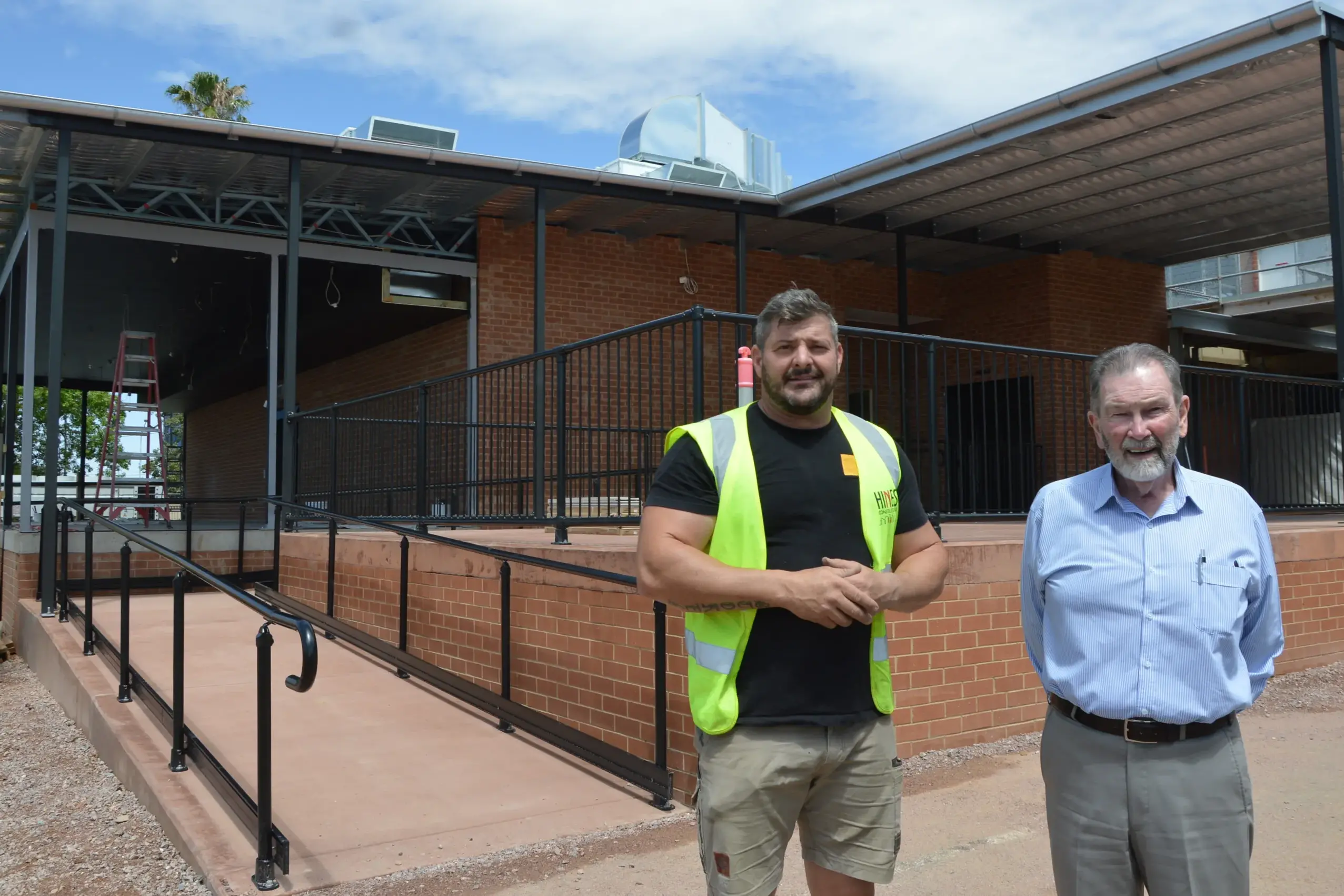 <p>Hines Construction site manager Mark Stokes and Parkes Services Club general manager Denis Lane in front of the new extension and back entrance for members at the Parkes Services Club. PHOTOS: Madeline Blackstock</p>\\n