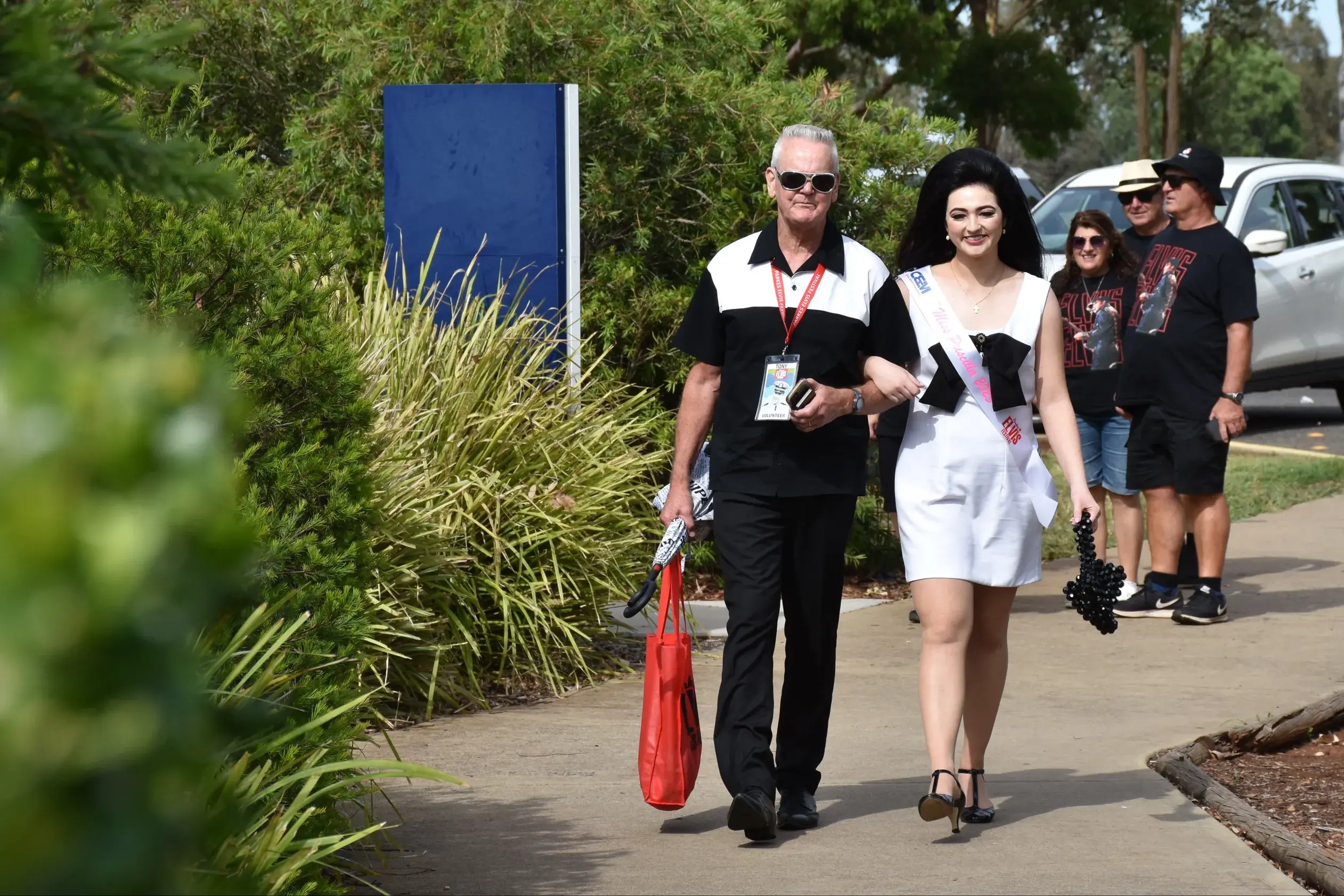 <p>Parkes volunteer Tony Fisher escorts 2025 Miss Priscilla Gracey Denham Jones to her photo shoot at the Dish during the Parkes Elvis Festival. PHOTO: Keith Turk</p>\\n