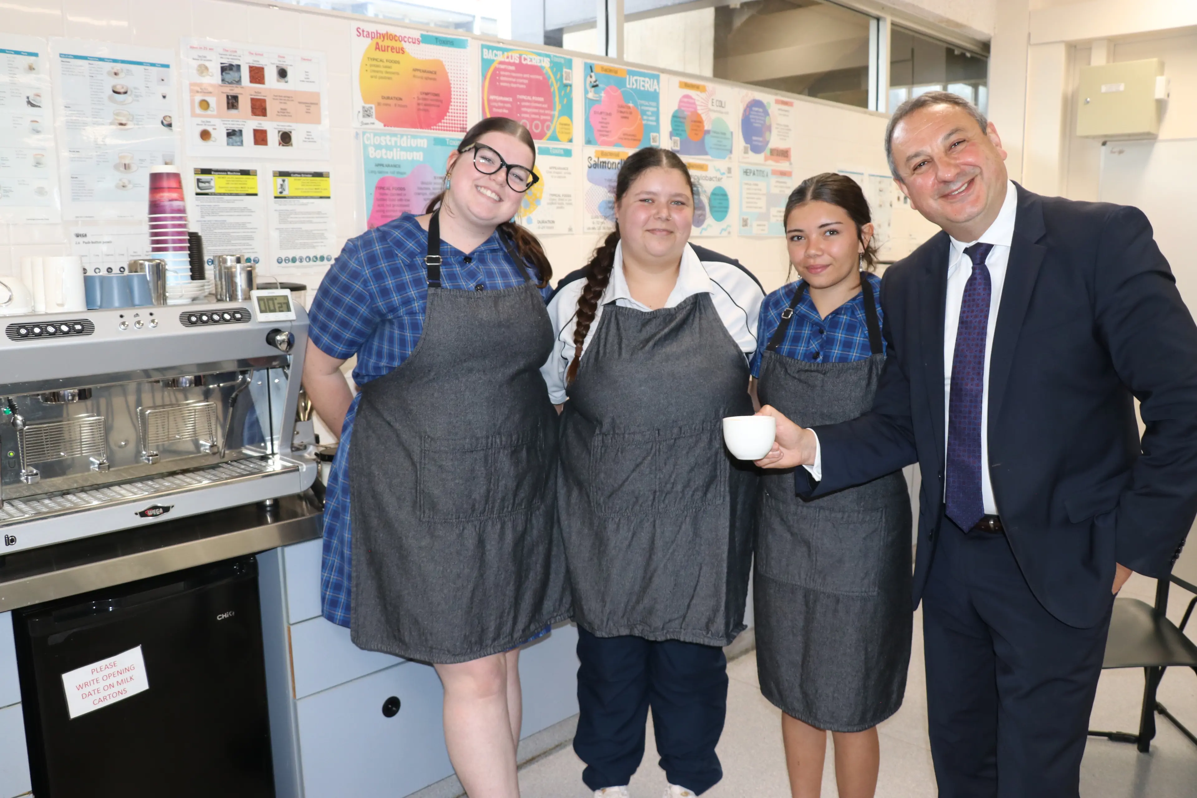 <p>Murat Dizdar PSM, Secretary of the NSW Department of Education, learnt to make a terrific coffee with hospitality students Bella Henry, Julia Sullivan and KC Austral. </p>\\n