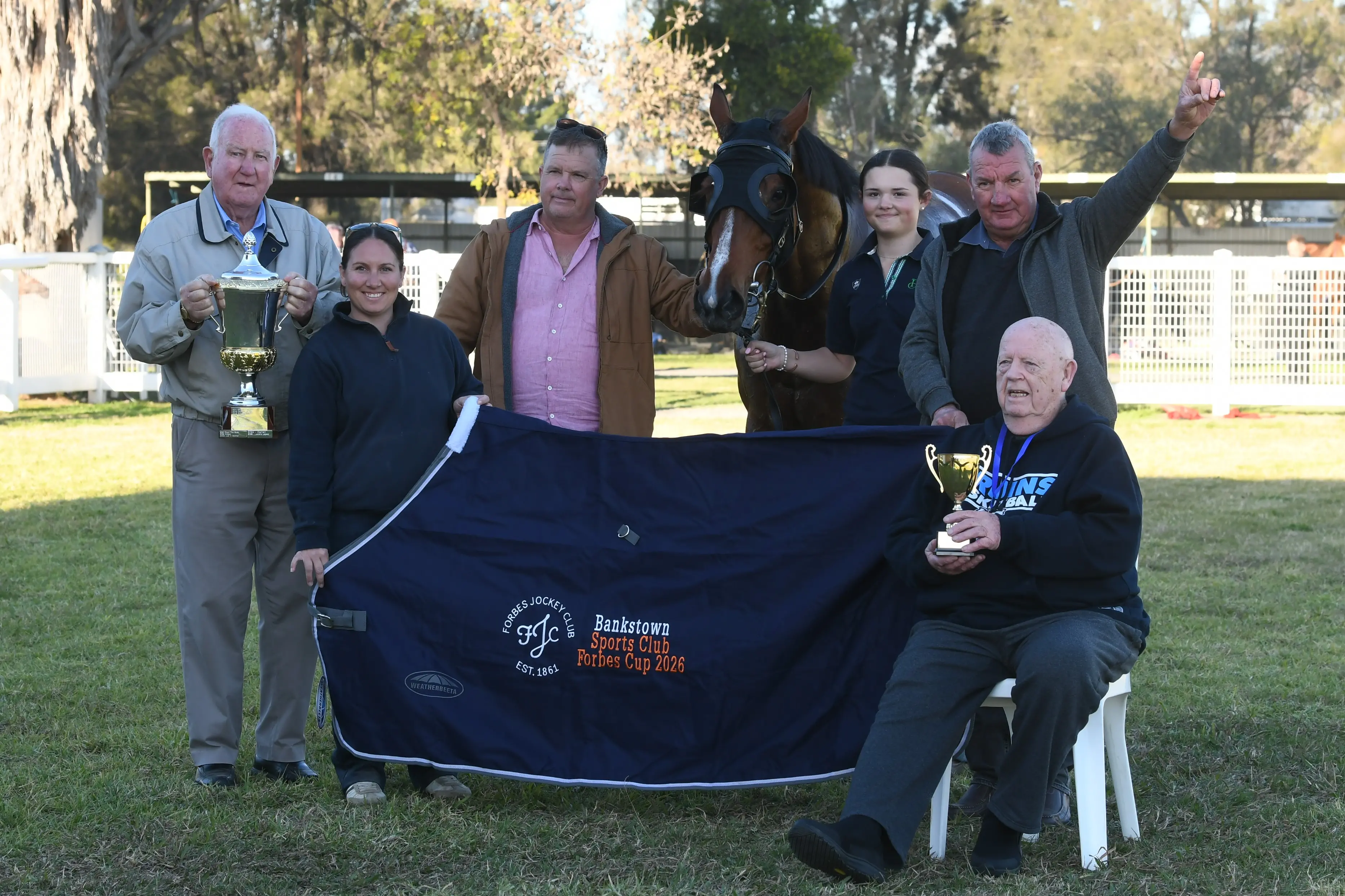<p>John Rennick from Forbes Jockey Club and Dick Phillips from Bankstown Sports Club with Cup-winning connections of Voracious - Mack Griffith, Britney Simpson, strapper Montana Griffith and Peter Rees. </p>\\n