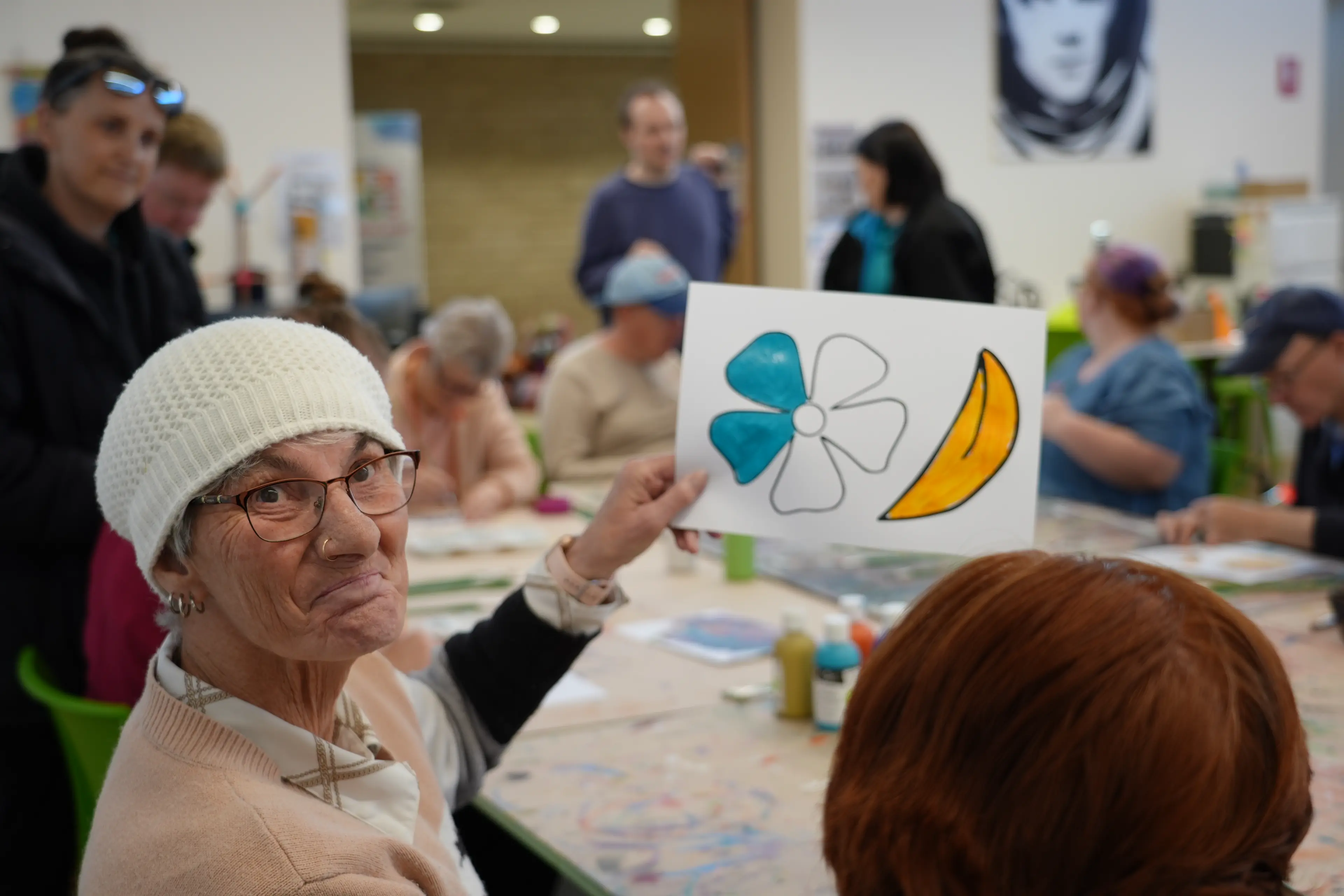 <p>Donna Apps shows off her artwork during one of the Changing Places creative workshops.</p>\\n